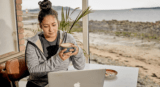 Image of woman working remotely by the coast
